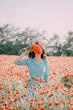 © Alex Photo - Young woman covered her face with bouquet of red poppies outdoor.