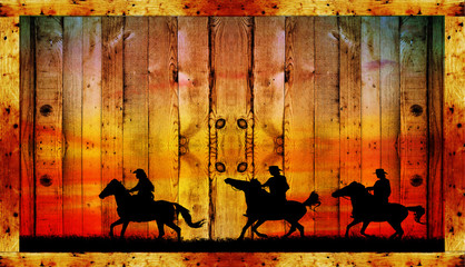 Silhouette of a cowboy riding a wild horse at sunset on a wooden sign