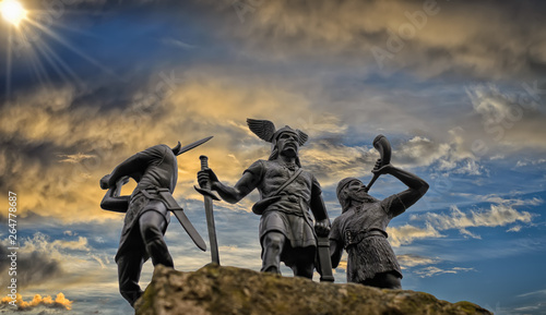 Fotografía Old Norse God Odin on a rock, flanked by two Vikings (toy soldiers), one of them