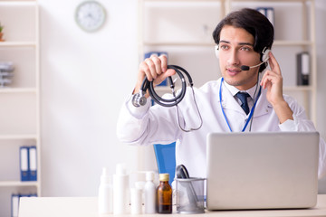 Young male doctor in telemedicine concept 