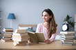 © BestForYou - Beautiful smiling female student reads books at home.