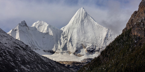 Wall Mural - Jampayang, epic snow mountain in Daocheng Yading Nature Reserve - Garze, Kham Tibetan Pilgrimage region of Sichuan Province China. Alpine grassland in front of the towering ice summit of Yangmaiyong