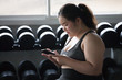 young asian fat  fitness woman using smartphone and relaxing in gym . sport  Overweight girl taking a break after exercises workout . obese female resting . chubby give up. lifestyle