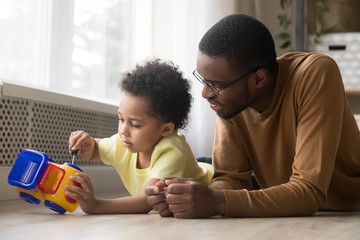 Cute son and african father playing together repair toy truck