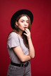 © F8  \ Suport Ukraine - Young pretty woman with black hat standing isolated on red background
