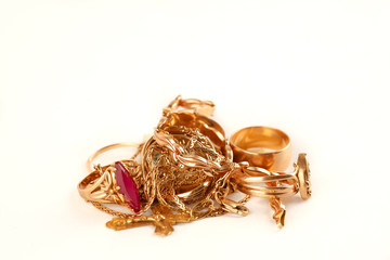 Pile of gold jewellery on a white background