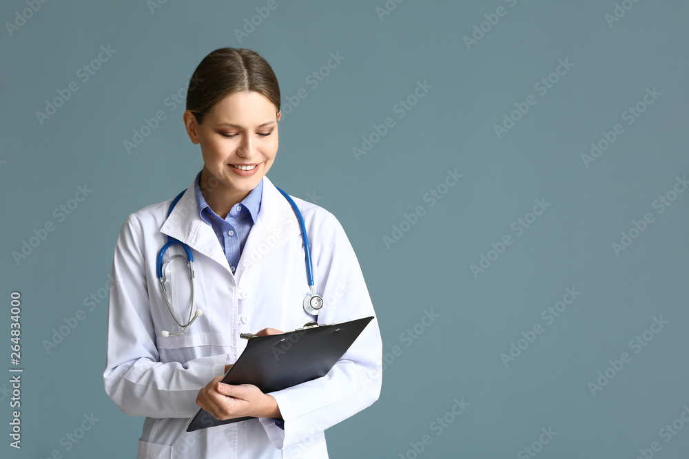 Portrait of young gynecologist on grey background