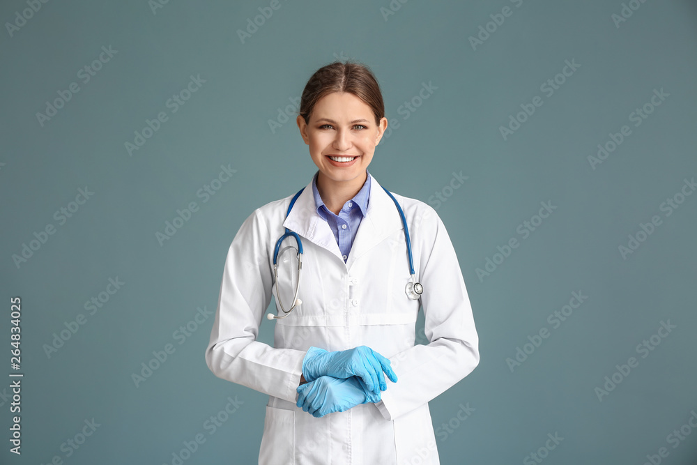 Portrait of young gynecologist on grey background