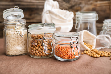 Glass jars with different food on kitchen table