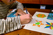 © Massimo Parisi - A black-haired Caucasian boy with glasses does his technical drawing homework