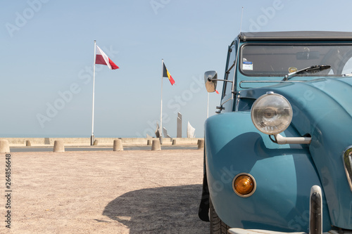 Fotografía Citroen 2CV, Ente, Reflektor und Seitenansicht mit Fahnen im Hintergrund