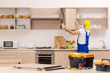 Aged contractor repairman working in the kitchen 