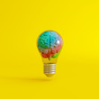 Colorful brain with a lightbulb on yellow background. Creative idea concept. 3d rendering