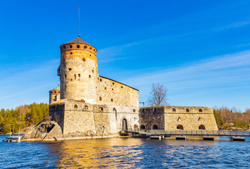 Beautiful view of Olavinlinna, Olofsborg ancient fortress, the 15th-century medieval three - tower castle located in Savonlinna city on a sunny May day. lake Saimaa, Finland.