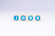 Das Wort JOBS auf Würfeln mit blauer Schrift und weißem Hintergrund