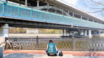 Wall Mural - moscow city russia metro bridge over moskva river embankment street view of luzhniki train station from park ground with female person relaxing on bench at sunny spring day town lifestyle landscape