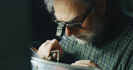 Wall Mural - Slow motion of experienced goldsmith working on a handmade jewelry ring with precious diamond stones in a workshop. Concept of jewelry, luxury, goldsmith, diamonds, brilliance.