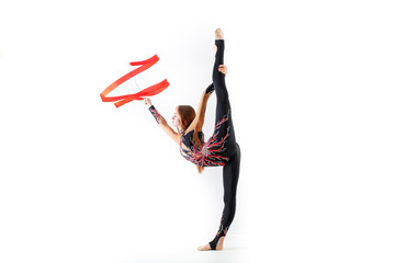 Rhythmic gymnastics. Young gymnast woman with red ribbon on white background