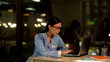 © motortion - Attractive office worker typing on laptop at night, internet research, job