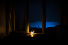 Night Scene Of Stars Seen Through The Window From Dark Room. Night Sky Inside Dark Room. Long Exposure Shot