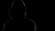 Close up of faceless male silhouette standing against black background, criminal