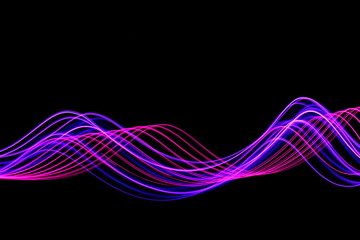Wall Mural - Long exposure, light painting photography.  An abstract wave of vibrant neon pink and purple color against a black background.