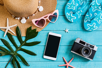 Wall Mural - Travel accessories items with smart phone on wooden background, Summer vacation concept