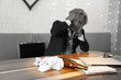 © feeling lucky - image of empty alcohol bottle on wood table with senior businessman who holding his head with stress because of failure in business blurred background