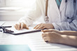 © rogerphoto - Doctor and patient are discussing something in clinic, just hands at the desk. Medicine and best service concept