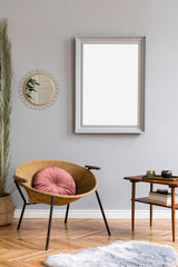 Stylish and luxury interior of with design honey yellow armchair, gray mock up frame, gold mirror, palm leaves and pillow Retro small table with elegant accessories. Modern home decor of living room.