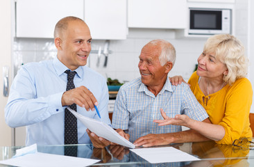 Man and woman signing agreement papers with social worker