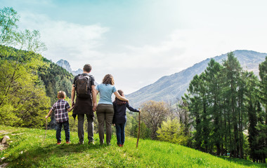 family on a green meadow looking at the mountain panorama