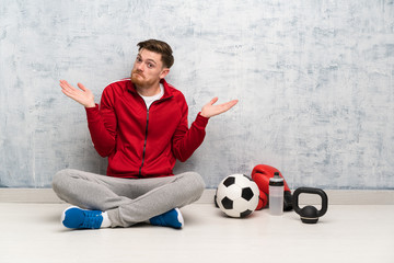 Wall Mural - Redhead sport man making doubts gesture