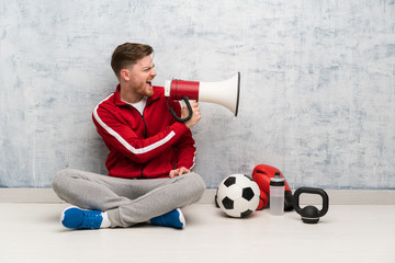 Wall Mural - Redhead sport man shouting through a megaphone