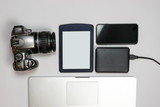 Fototapeta  - Header with a stylish workspace with laptop computer, smartphone and other gadgets on a white table, top view