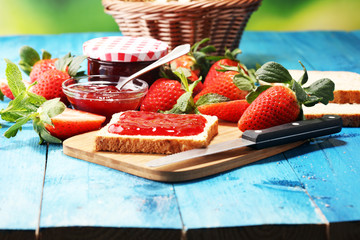 Toast bread with homemade strawberry jam or marmalade on table served with butter for breakfast or brunch