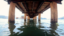 View From Under The Wooden Pier On Calm Sea Waves