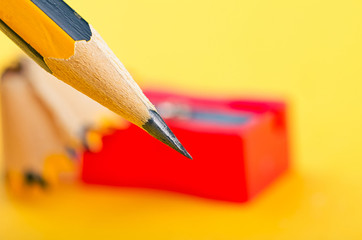 Back To school Concept, pencil with it shavings and sharpener over yellow background