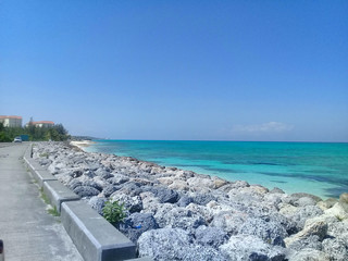 view of the sea and beach, with rocks along the shore