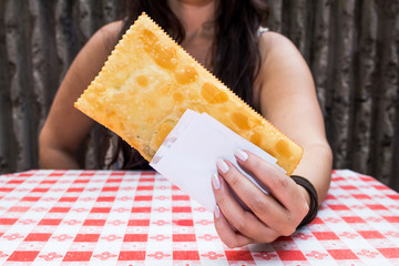 Young woman holding brazilian snack known as Pastel - asian recipe.