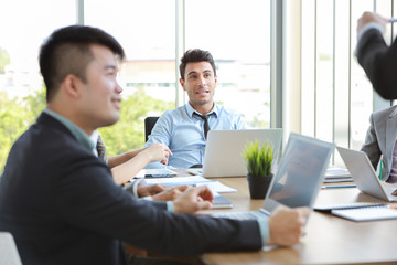 caucasian businessman listening lecturer giving public presentation with attention in multiethnic business people meeting