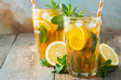 © Vasiliy - Traditional iced tea with lemon and ice in tall glasses on a wooden rustic table. With copy space