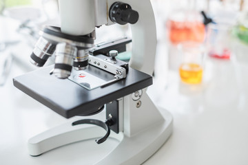 Wall Mural - microscope in bright white laboratory with color chemical blur in background