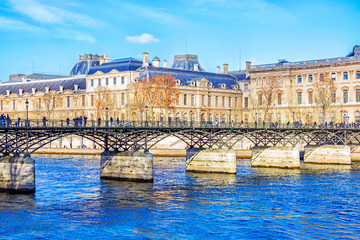 Wall Mural - View of Pont des Arts bridge and Louvre Museum across Seine river in Paris, France