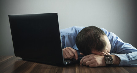 Wall Mural - Caucasian young businessman sleeping on the desk. Business concept