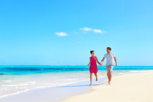 Beach Vacation Honeymoon Paradise Travel Destination - Young Couple In Love Walking Holding Hands In Idyllic Holiday Background.