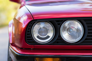 Wall Mural - Headlights of a red, old, retro car, closeup