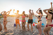 © oneinchpunch - Group of friends partying at the beach