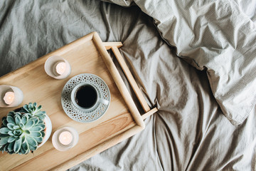 Wall Mural - Morning breakfast with coffee in bed. Flat lay, top view lifestyle still life composition. Wooden tray and grey linen.