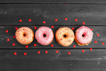 Poster - Colorful fresh donuts on dark black wooden surface